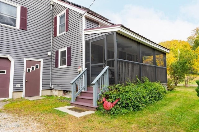 rear view of property with a sunroom and a yard