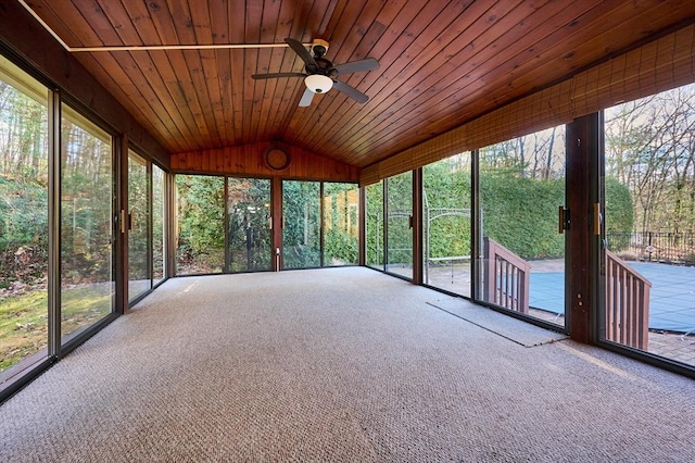 unfurnished sunroom featuring ceiling fan, vaulted ceiling, plenty of natural light, and wood ceiling