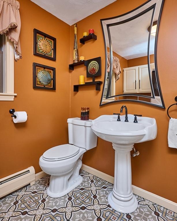 bathroom featuring tile patterned floors, toilet, and a baseboard radiator