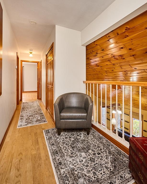 hall featuring light hardwood / wood-style flooring and wooden ceiling