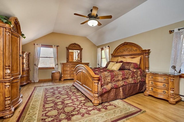 bedroom featuring light hardwood / wood-style flooring, multiple windows, lofted ceiling, and ceiling fan