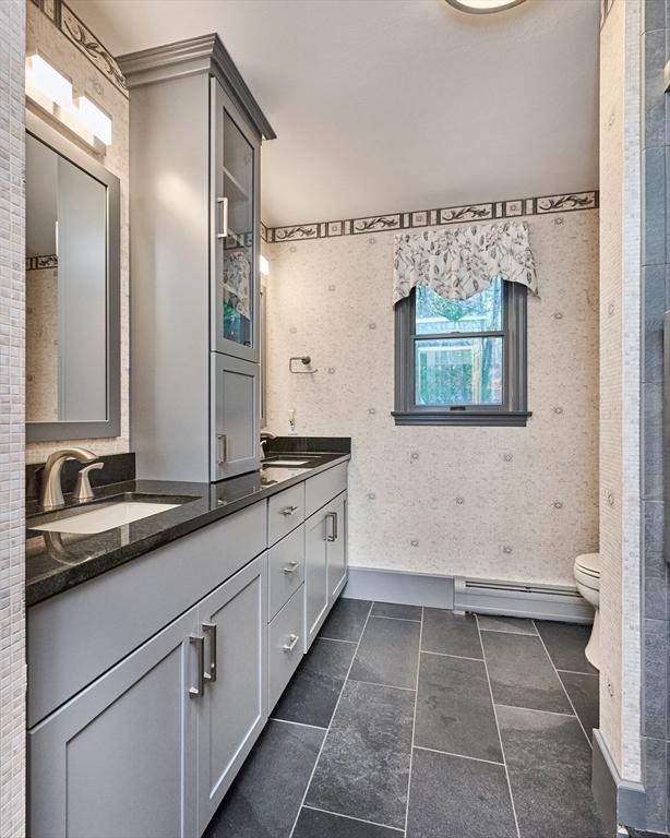 bathroom featuring vanity, toilet, and a baseboard heating unit