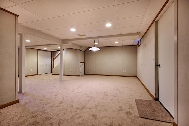 basement with light carpet and a paneled ceiling