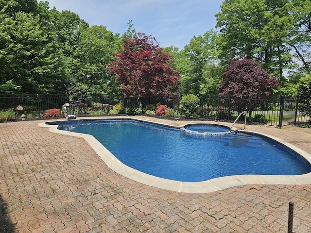 view of pool with an in ground hot tub and a patio