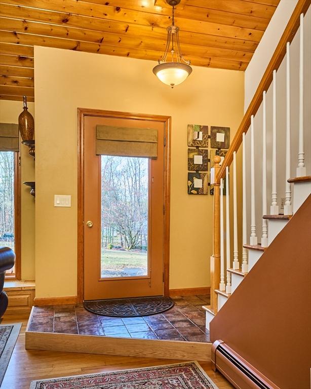 foyer entrance featuring wood-type flooring, a baseboard heating unit, and wood ceiling