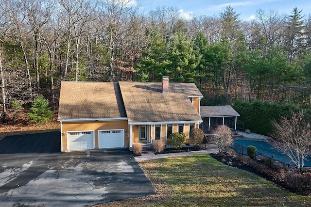 new england style home featuring a garage and a front yard