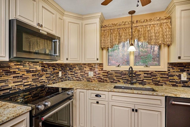 kitchen with decorative backsplash, light stone countertops, stainless steel appliances, sink, and hanging light fixtures