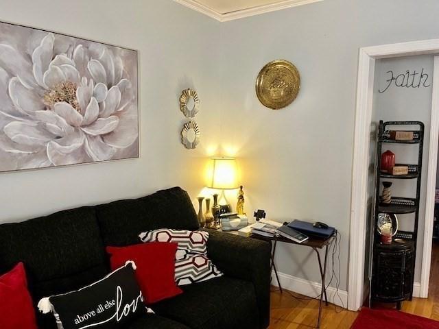 living room with wood-type flooring and ornamental molding