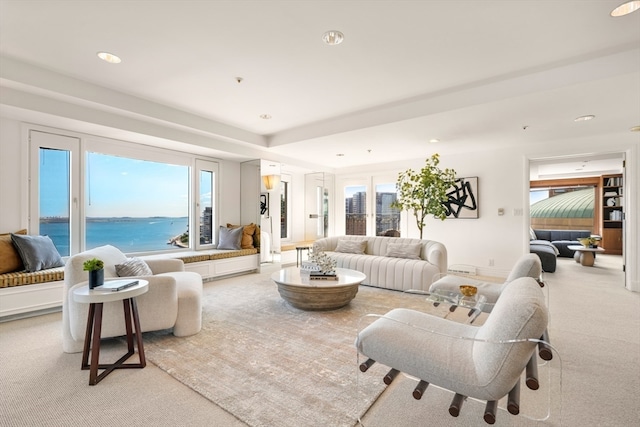 living room with a water view, light carpet, and a wealth of natural light