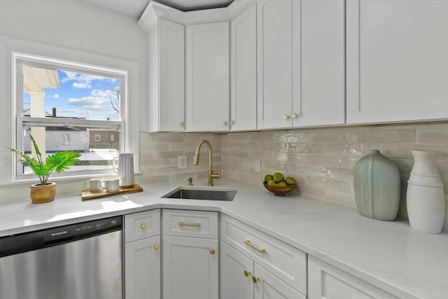 kitchen with light countertops, a sink, white cabinetry, decorative backsplash, and dishwasher