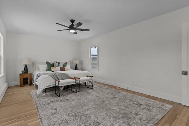 bedroom featuring baseboards, a ceiling fan, and light wood finished floors