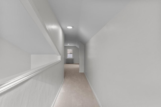 hallway featuring recessed lighting, vaulted ceiling, light colored carpet, and baseboards