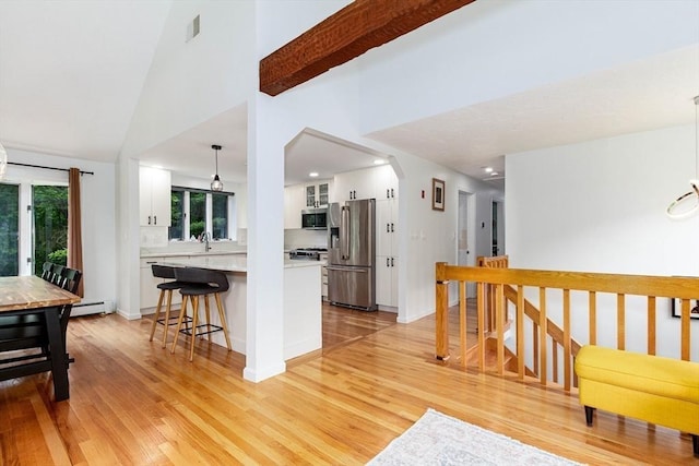 10 Longmeadow Ln, Medway, MA 02053 - kitchen with appliances with stainless steel finishes, white cabinets, light wood-style flooring, light countertops, and a breakfast bar area