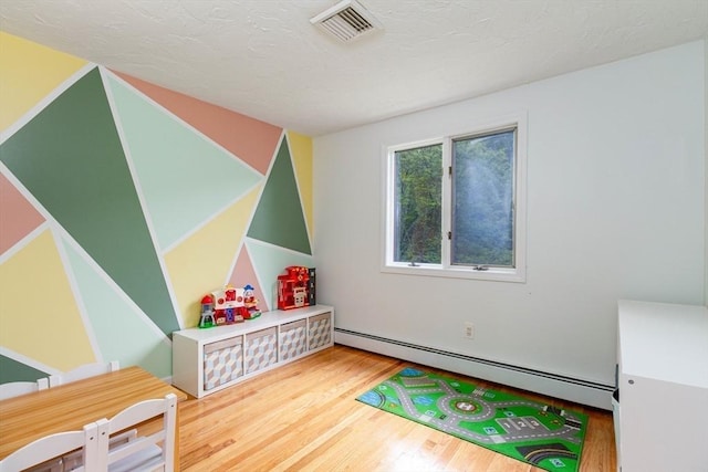 10 Longmeadow Ln, Medway, MA 02053 - recreation room featuring a baseboard heating unit, wood finished floors, and a textured ceiling