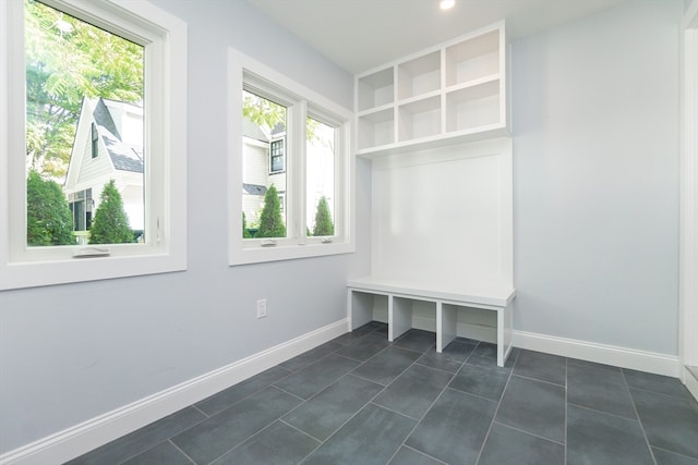 mudroom with dark tile patterned floors and a wealth of natural light