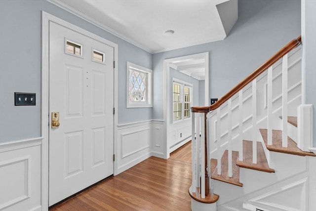 35 Crest Rd, Framingham, MA 01702 - entryway with wood finished floors, stairway, a wainscoted wall, crown molding, and a baseboard heating unit