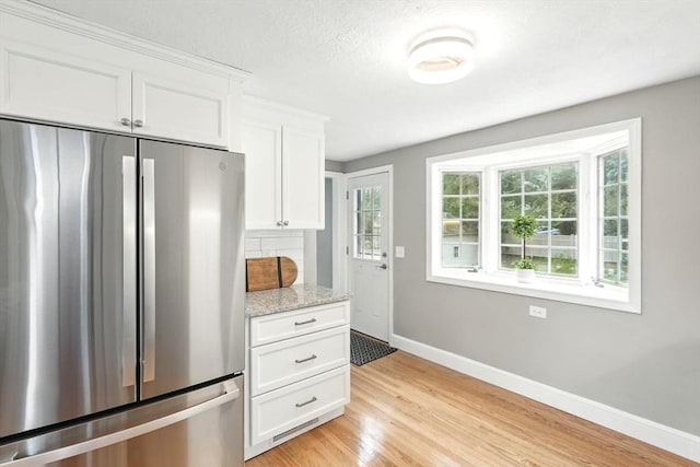 132 Nelson St, West Springfield, MA 01089 - kitchen with freestanding refrigerator, light wood finished floors, white cabinets, and light stone countertops