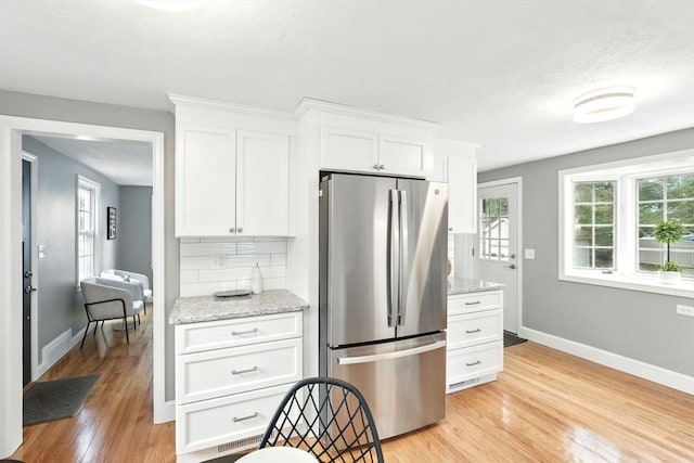 132 Nelson St, West Springfield, MA 01089 - kitchen with freestanding refrigerator, light wood finished floors, healthy amount of natural light, and white cabinetry