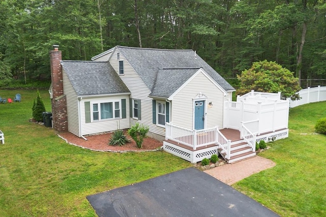 649 Robin Hill St, Marlborough, MA 01752 - view of front facade with roof with shingles, a chimney, a wooden deck, and a view of trees