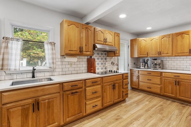 649 Robin Hill St, Marlborough, MA 01752 - kitchen with under cabinet range hood, beamed ceiling, light countertops, light wood finished floors, and black electric cooktop