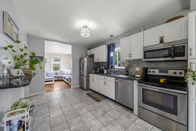 150 Church Ave, Warwick, RI 02889 - kitchen featuring appliances with stainless steel finishes, dark countertops, plenty of natural light, and backsplash