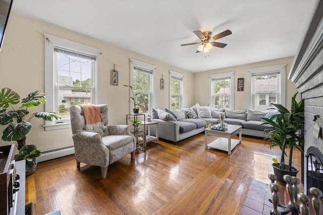 150 Church Ave, Warwick, RI 02889 - living room featuring baseboard heating, ceiling fan, wood finished floors, and a brick fireplace