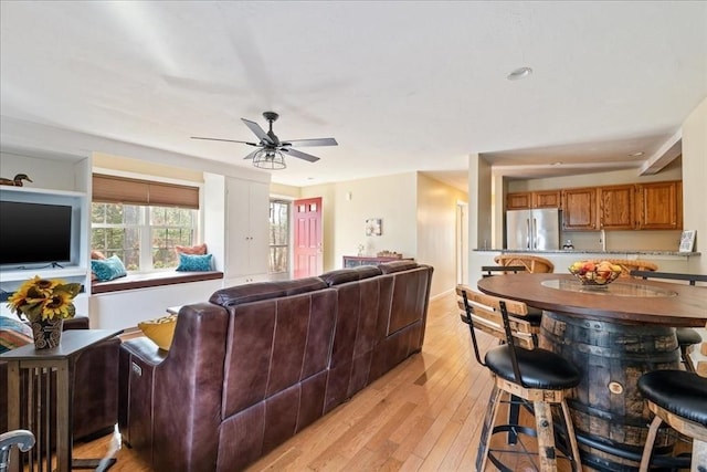 living area featuring a ceiling fan and light wood finished floors