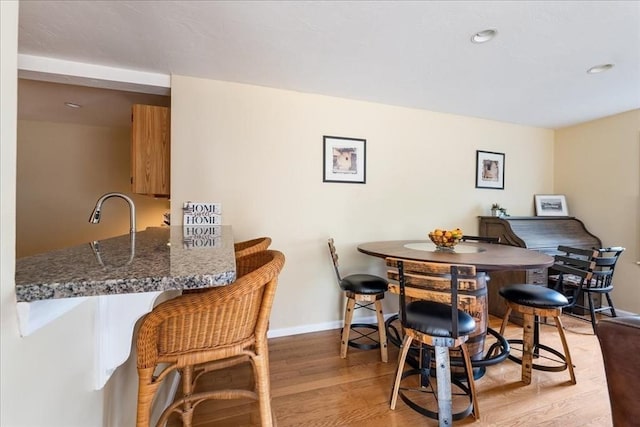 dining room with recessed lighting, light wood-style flooring, and baseboards