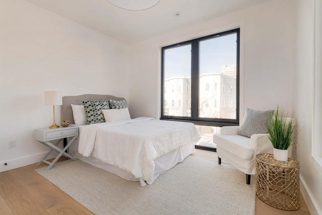 bedroom with hardwood / wood-style flooring and multiple windows