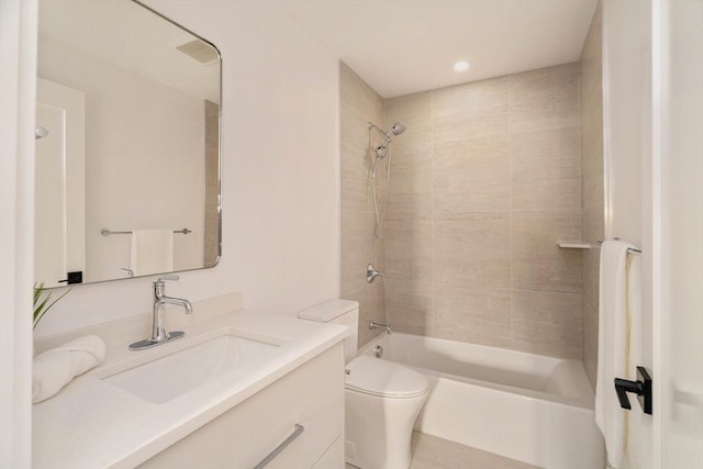 full bathroom featuring vanity, tiled shower / bath combo, and toilet