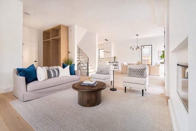 living room featuring an inviting chandelier and light hardwood / wood-style flooring