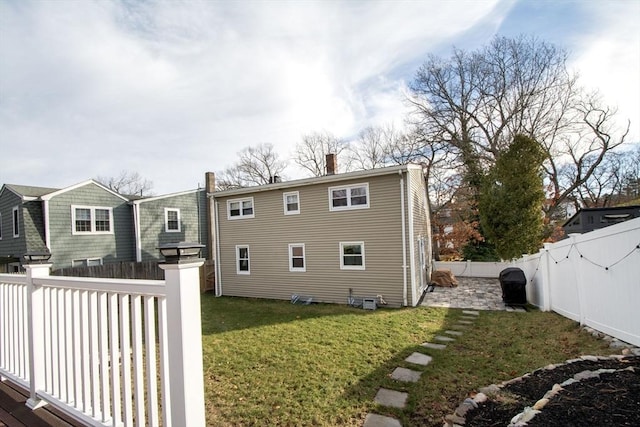 rear view of property with a lawn