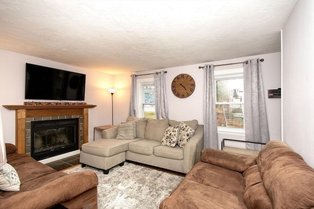 living room featuring a tile fireplace and a textured ceiling