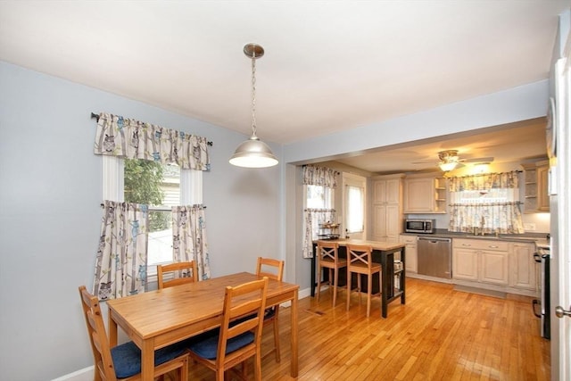 dining room with ceiling fan, sink, and light hardwood / wood-style floors