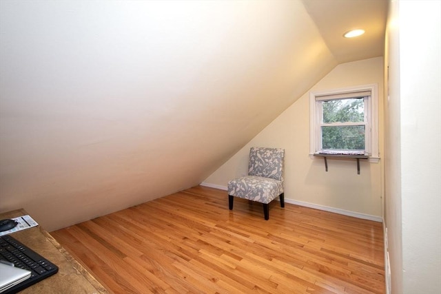 unfurnished room featuring light wood-type flooring and vaulted ceiling