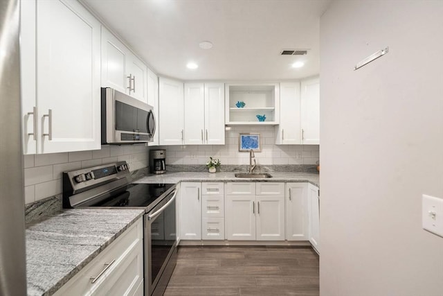 42 2nd Ave Unit 40, North Attleboro, MA 02760 - kitchen with stainless steel appliances, open shelves, decorative backsplash, white cabinetry, and dark wood-style floors