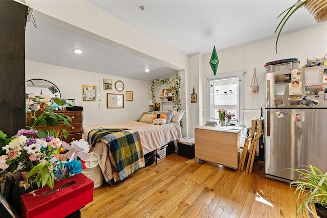 bedroom featuring freestanding refrigerator and light wood finished floors
