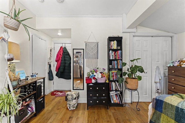 interior space featuring a closet, ornamental molding, and wood finished floors