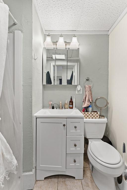 full bathroom featuring toilet, tile patterned floors, a shower with shower curtain, and vanity