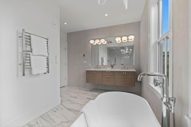 559 E Broadway Unit 559, Boston, MA 02127 - full bathroom featuring marble finish flooring, a soaking tub, a towel warming rack, double vanity, and recessed lighting