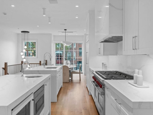 559 E Broadway Unit 559, Boston, MA 02127 - kitchen featuring stainless steel appliances, custom range hood, a large island with sink, white cabinetry, and recessed lighting