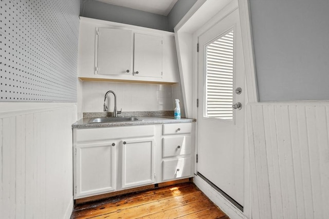 109 Eutaw St, Boston, MA 02128 - interior space featuring a sink, light wood-type flooring, wood walls, and a wainscoted wall