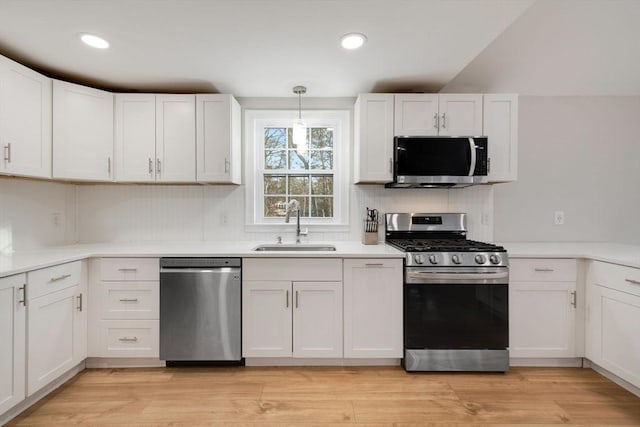 kitchen with a sink, white cabinets, and stainless steel appliances