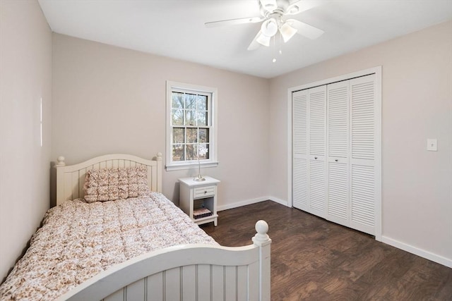 bedroom with dark wood-type flooring, baseboards, a closet, and ceiling fan