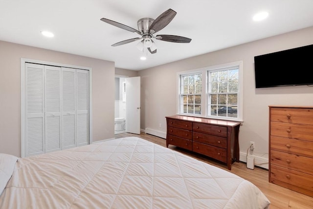 bedroom featuring wood finished floors, baseboards, recessed lighting, a closet, and a baseboard heating unit