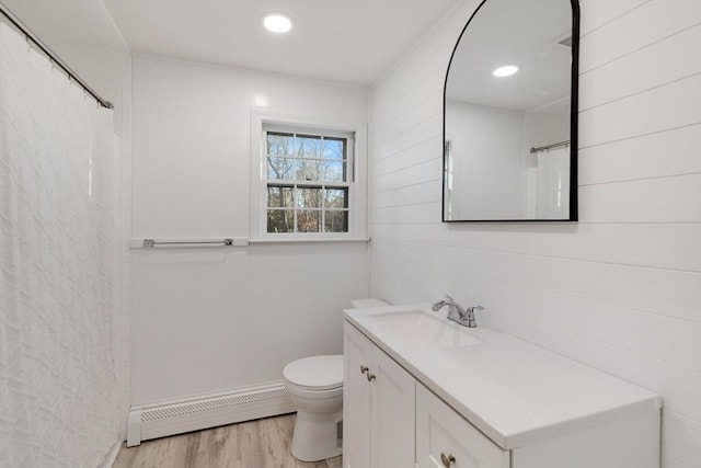 bathroom with toilet, a baseboard heating unit, wood finished floors, a shower with shower curtain, and vanity