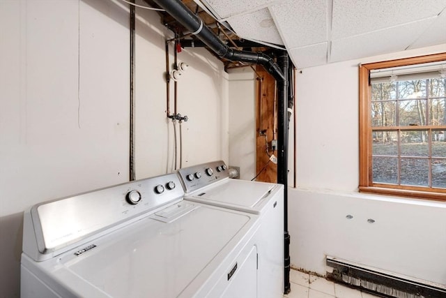 clothes washing area featuring baseboard heating, independent washer and dryer, and laundry area