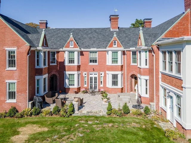 back of property featuring a patio and a yard