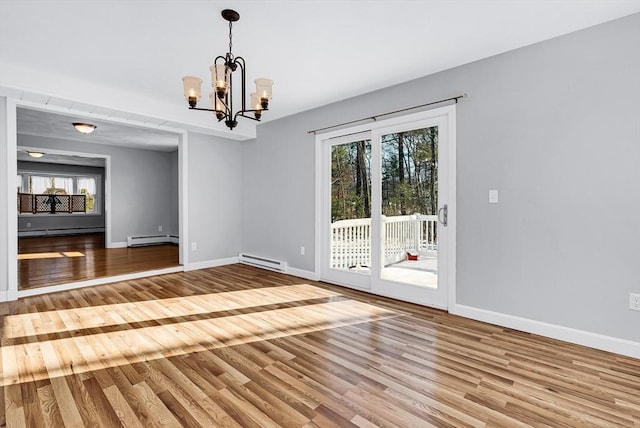 unfurnished dining area with a notable chandelier, hardwood / wood-style flooring, and baseboard heating