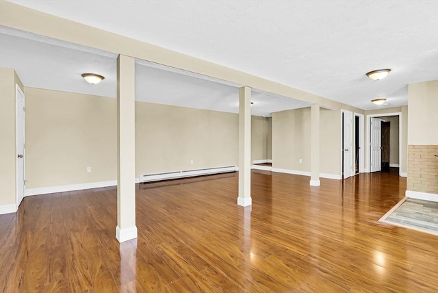 basement with a baseboard radiator and hardwood / wood-style floors